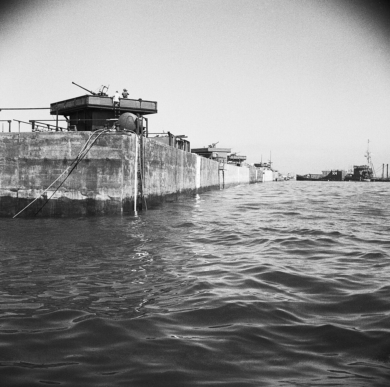 A line of Phoenix caisson units forming part of the Mulberry artificial harbour at Arromanches, 12 June 1944